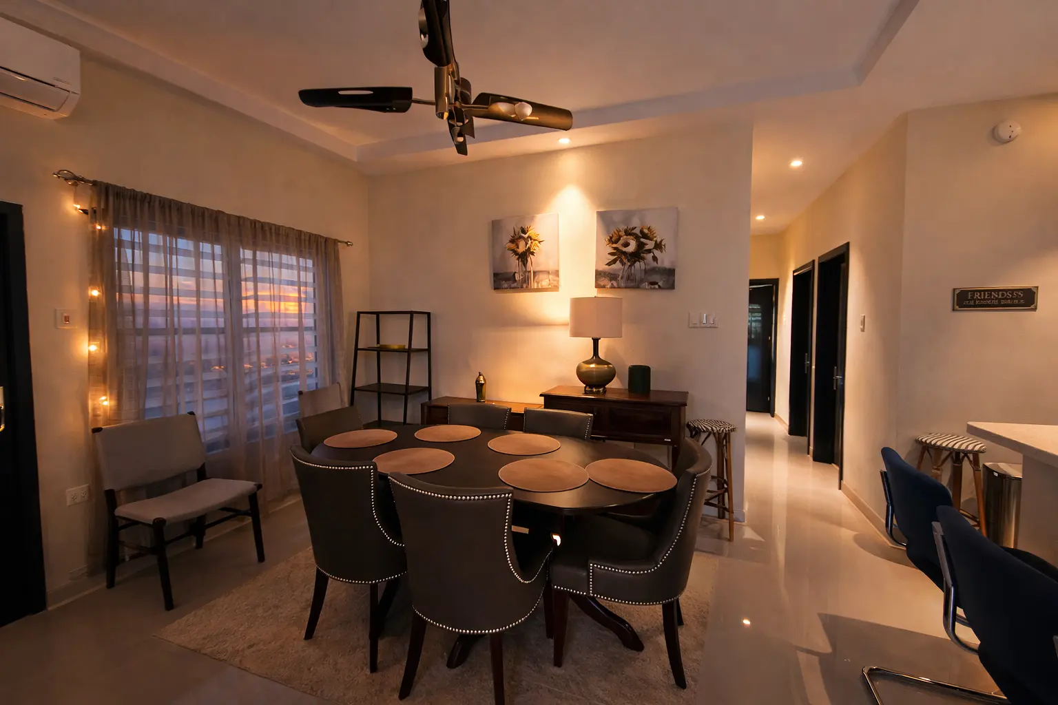 The dining room at dusk, a round table set for six with sunset through sheer curtains